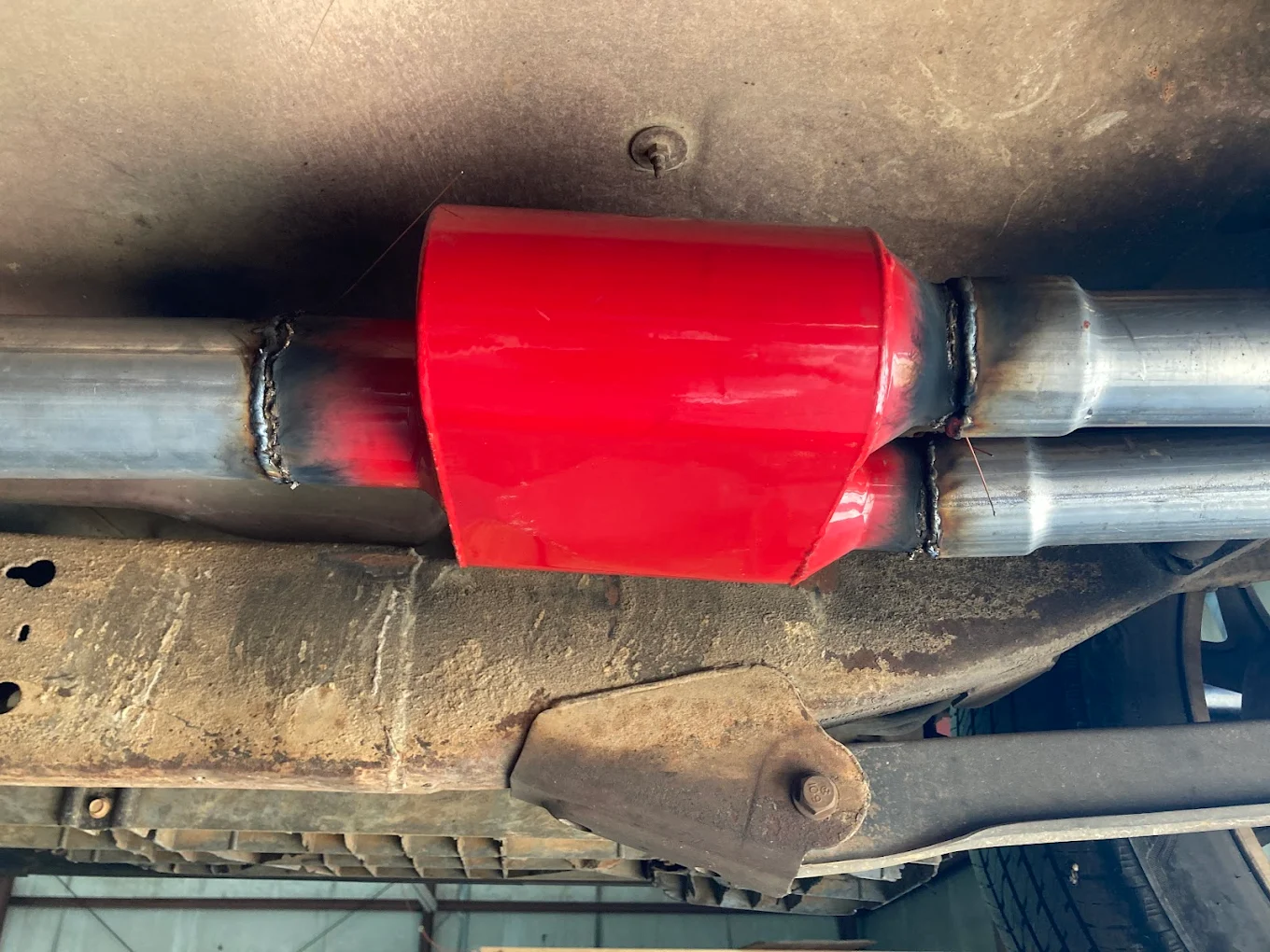 Custom red muffler install with clean weld work